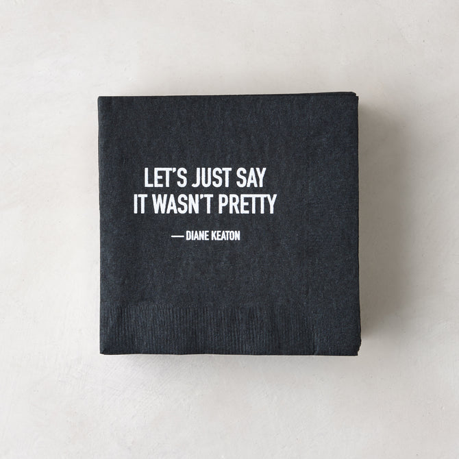 Black 5.5" square paper cocktail napkin with white "LET'S JUST SAY IT WASN'T PRETTY - DIANE KEATON" quote.