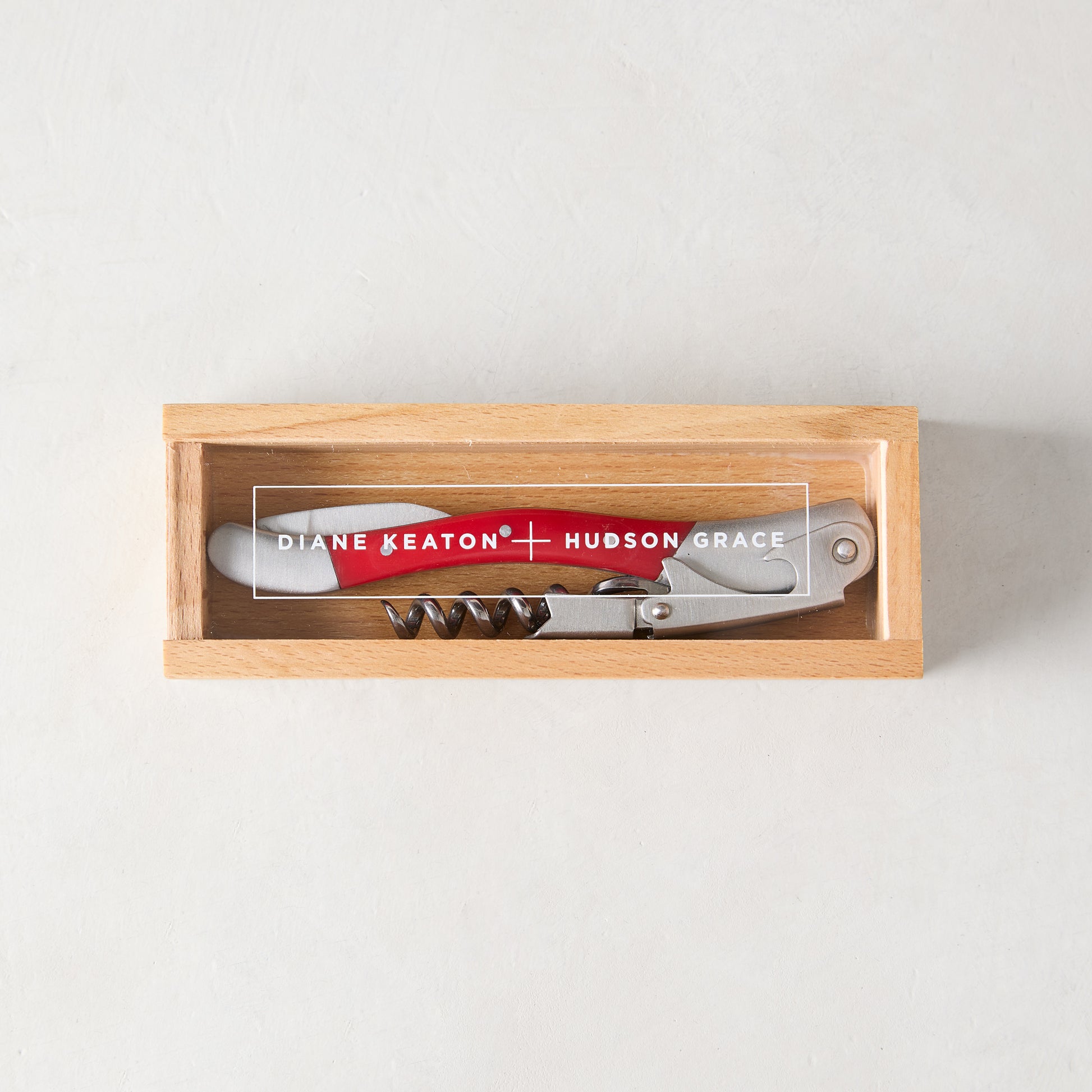 Diane Keaton + Hudson Grace "Keaton Red" wine corkscrew with red resin handle and stainless steel in a wooden gift box.