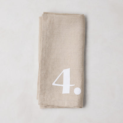 Diane Keaton + Hudson Grace Khaki Linen Numeric Napkin, folded with white number 4.
