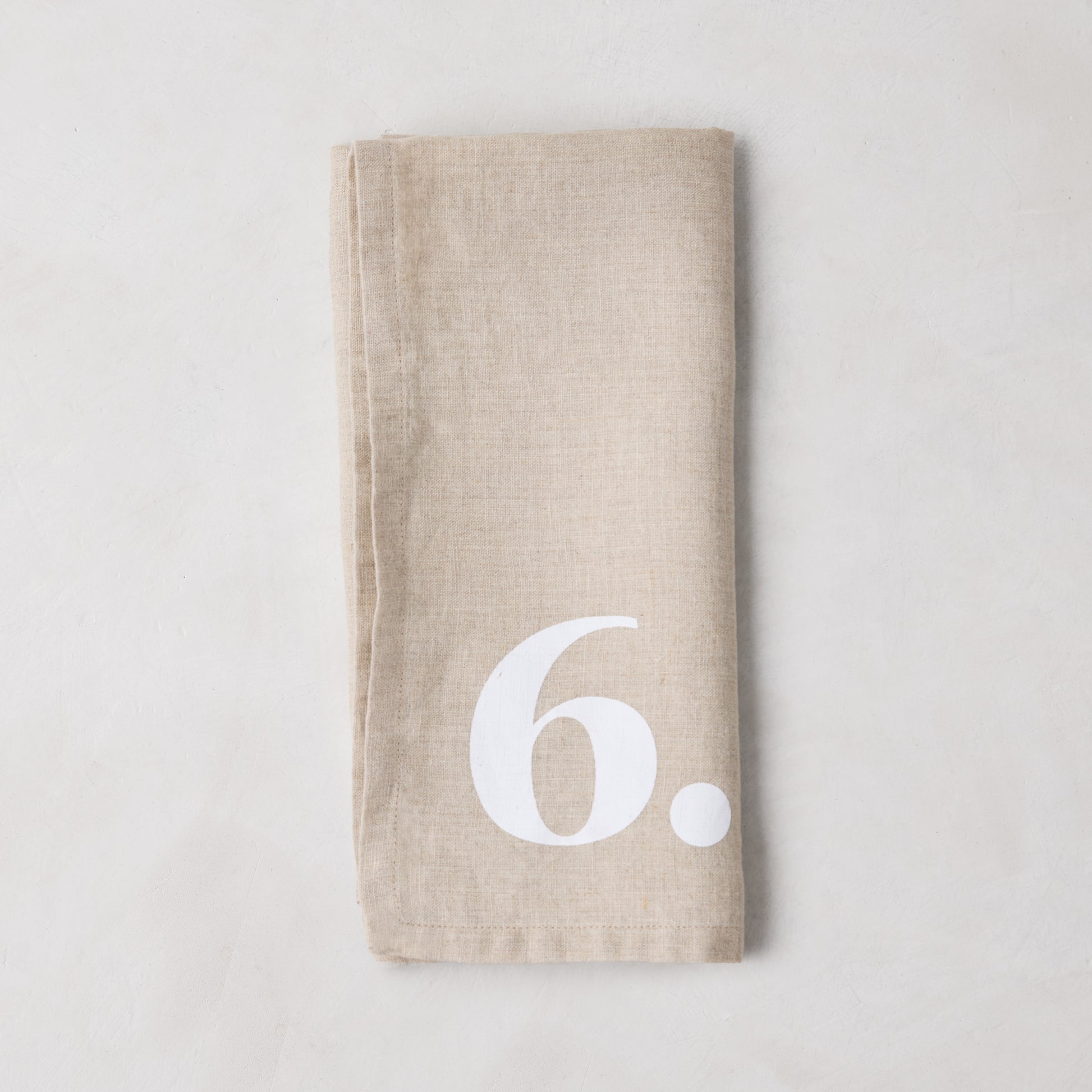 Diane Keaton + Hudson Grace Khaki Linen Numeric Napkin with a white number 6.