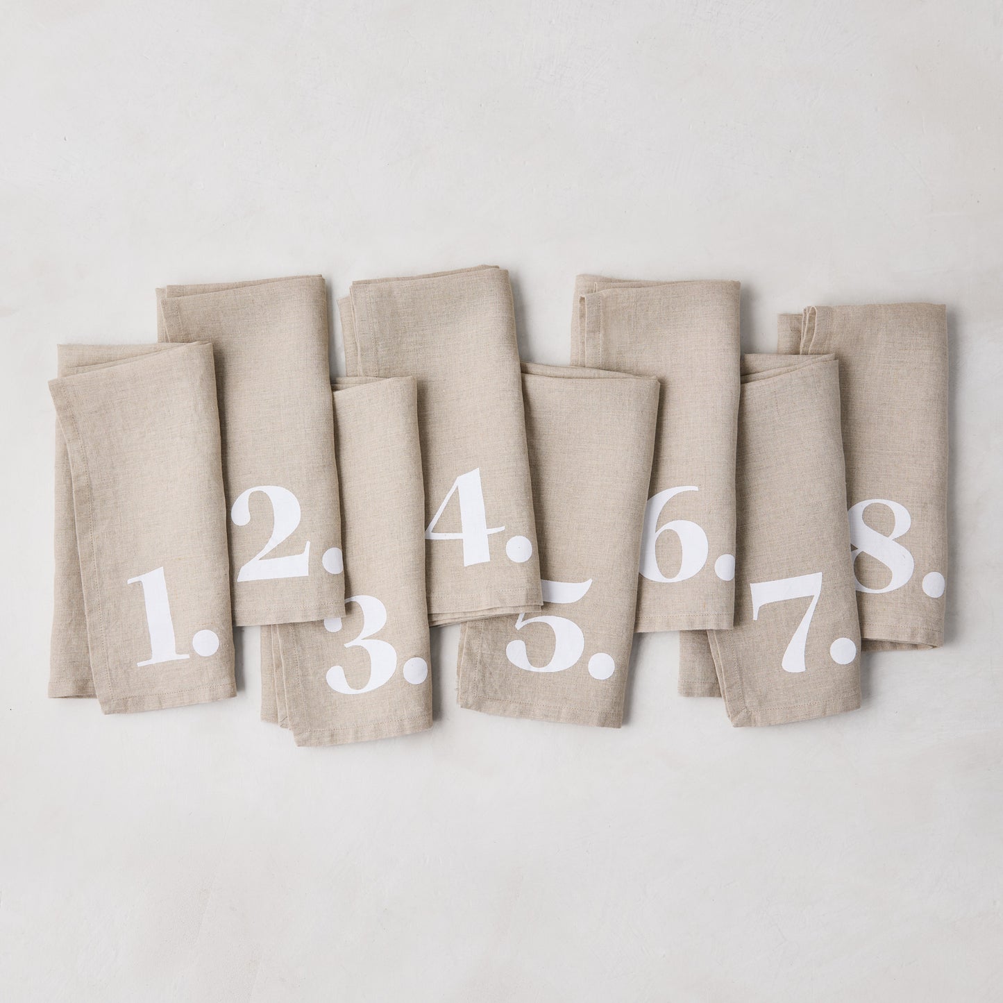 Diane Keaton + Hudson Grace Khaki Linen Numeric Napkins, set of 8, with white numbers 1-8.