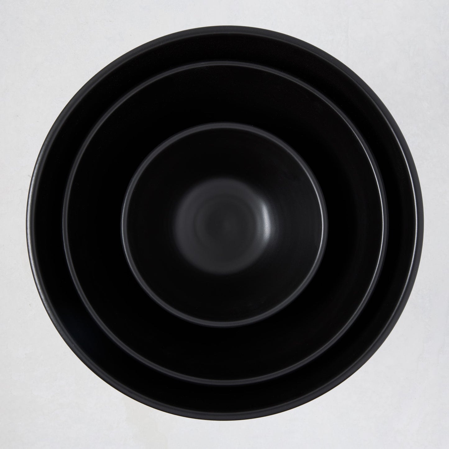 Diane Keaton + Hudson Grace matte black modern serve bowls, three sizes nested.