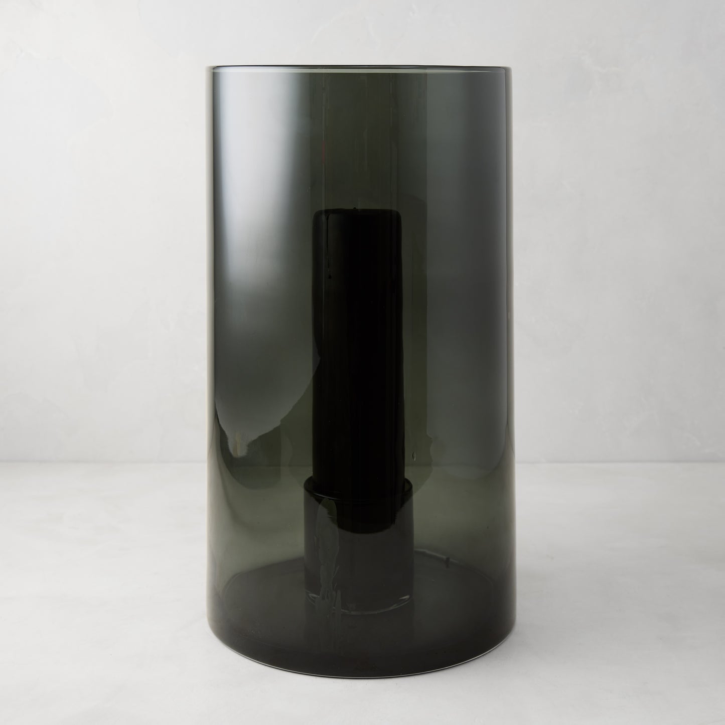 Large Diane Keaton + Hudson Grace smoke grey glass hurricane with dark pillar candle.