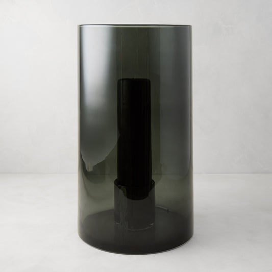 Large Diane Keaton + Hudson Grace smoke grey glass hurricane with dark pillar candle.