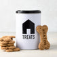 Diane Keaton x Hudson Grace white metal dog treat tin with black house icon, "TREATS" text, and black lid, next to dog biscuits.