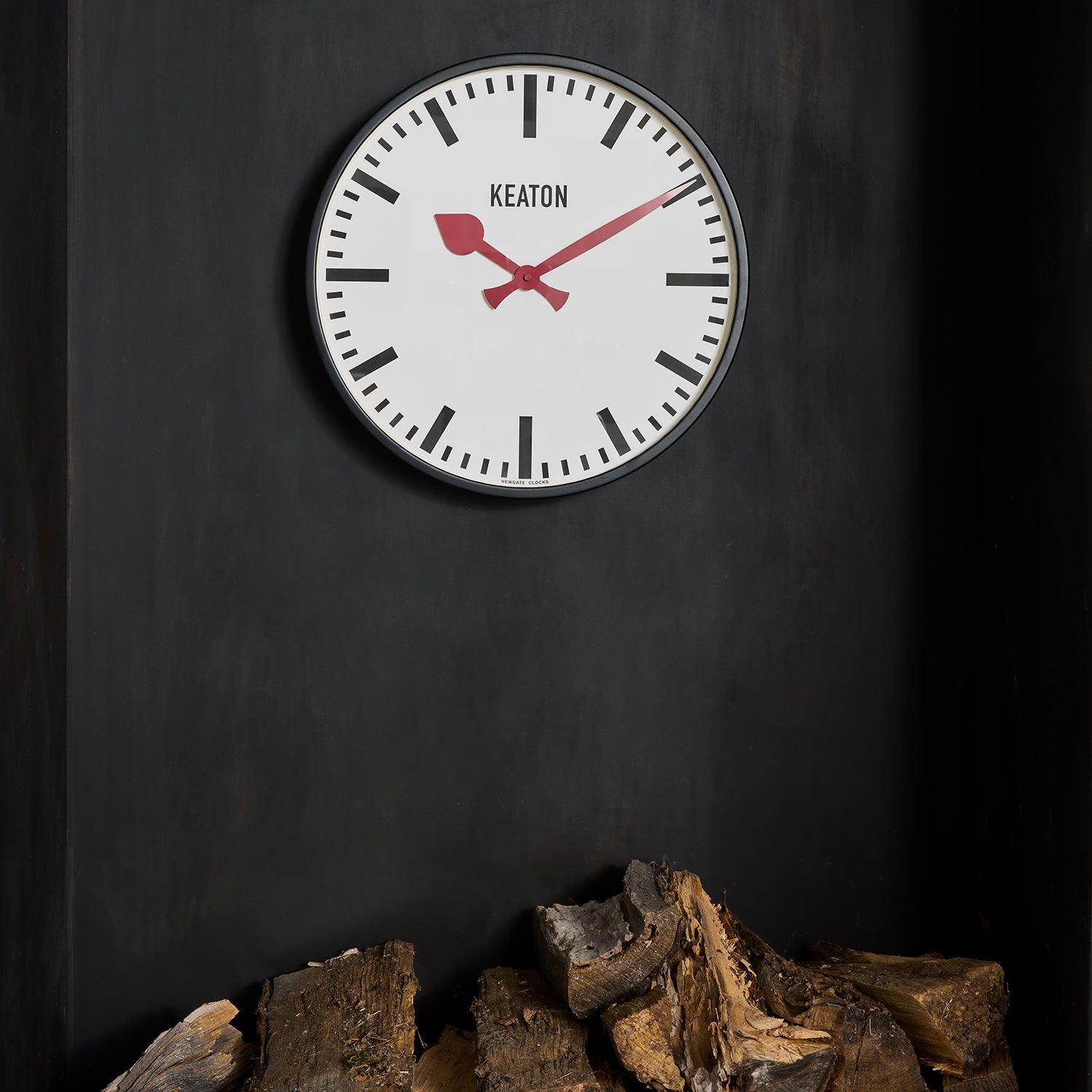 Diane Keaton + Hudson Grace Metro Wall Clock: black metal case, white dial, bold red hands, "KEATON" text.