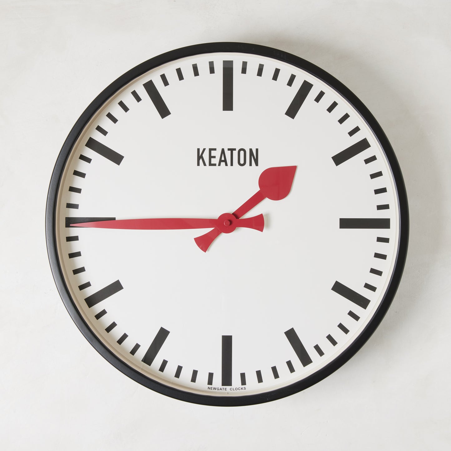 Diane Keaton x Hudson Grace Metro Wall Clock with black metal case, white dial, and vibrant red hands.