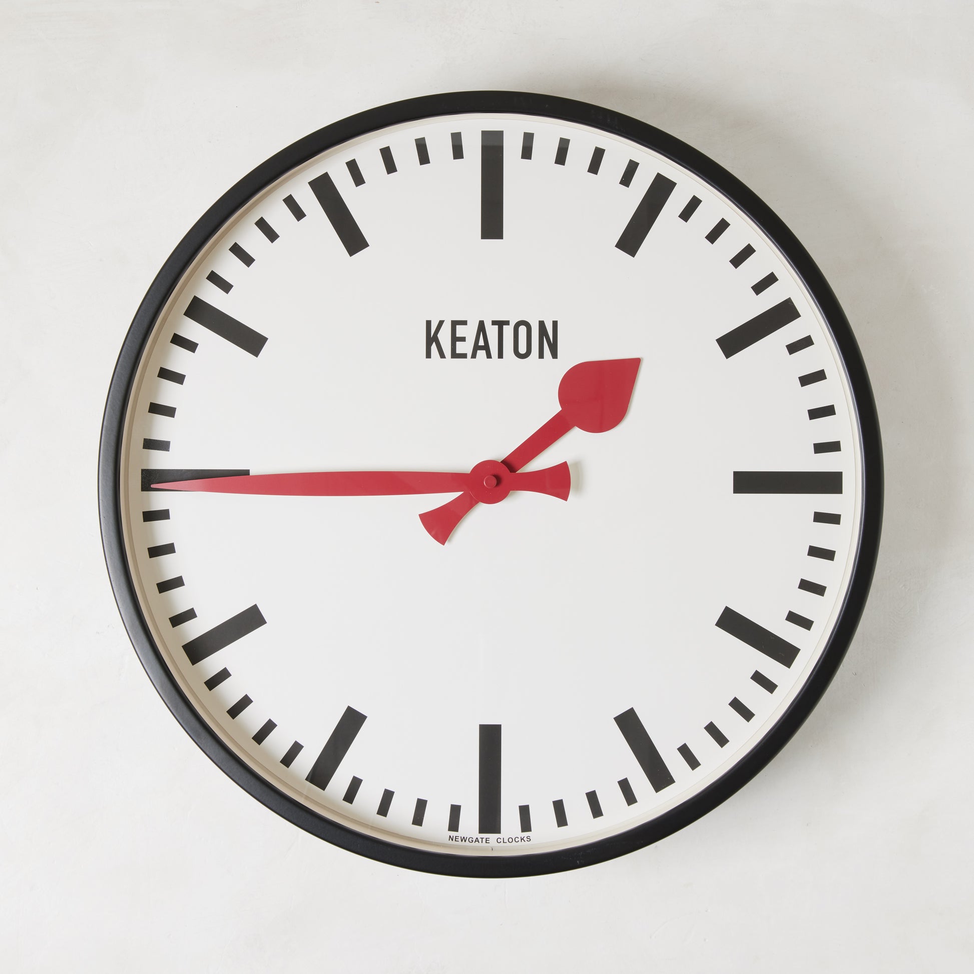 Diane Keaton x Hudson Grace Metro Wall Clock with black metal case, white dial, and vibrant red hands.