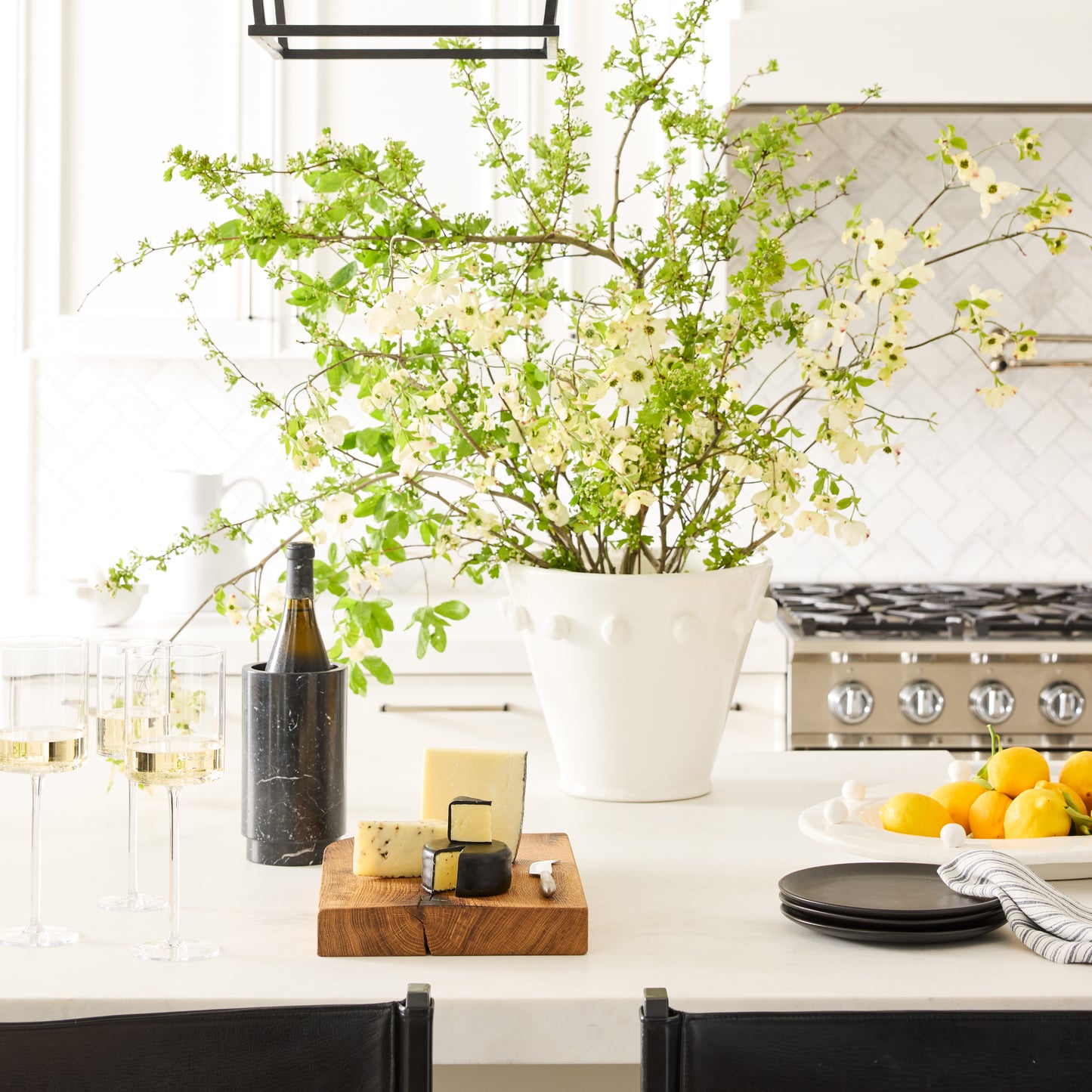 Diane Keaton + Hudson Grace Modern Dot Ceramic Centerpiece, white with polka dots, filled with green branches.