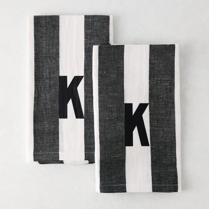 Set of 2 Diane Keaton + Hudson Grace monogrammed hand towels, grey and white striped, with black letter K.