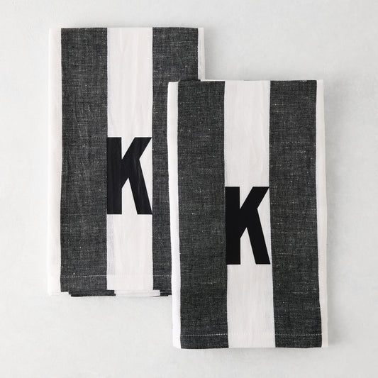 Set of 2 Diane Keaton + Hudson Grace monogrammed hand towels, grey and white striped, with black letter K.