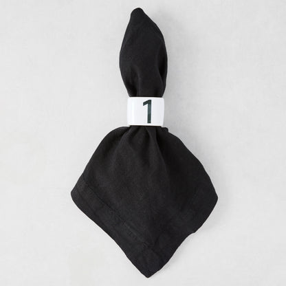 Diane Keaton + Hudson Grace white stoneware numeric napkin ring "1" on a black linen napkin.