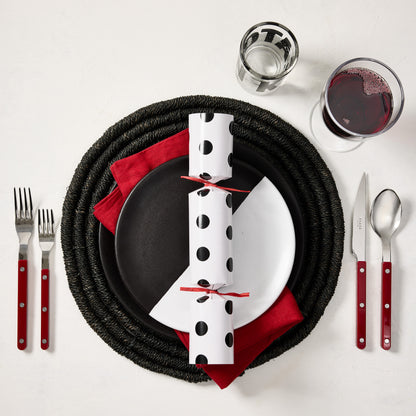 Diane Keaton + Hudson Grace polka dot Christmas cracker on a black and white plate with red napkin and cutlery.