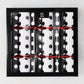 Diane Keaton + Hudson Grace polka dot Christmas crackers in black and white, tied with red string, in a black box.