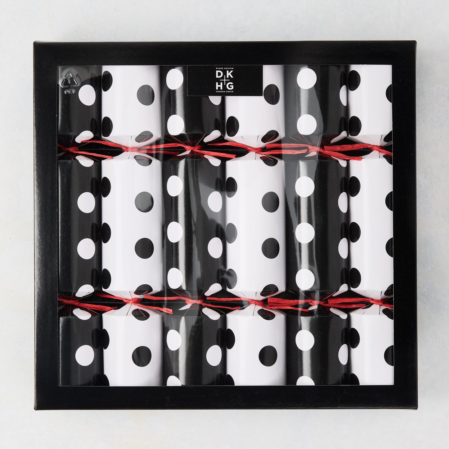 Diane Keaton + Hudson Grace polka dot Christmas crackers in black and white, tied with red string, in a black box.