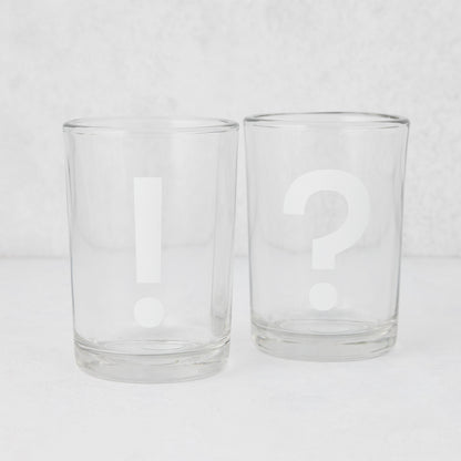 Two clear glass tumblers, one with a white exclamation mark, the other with a white question mark.