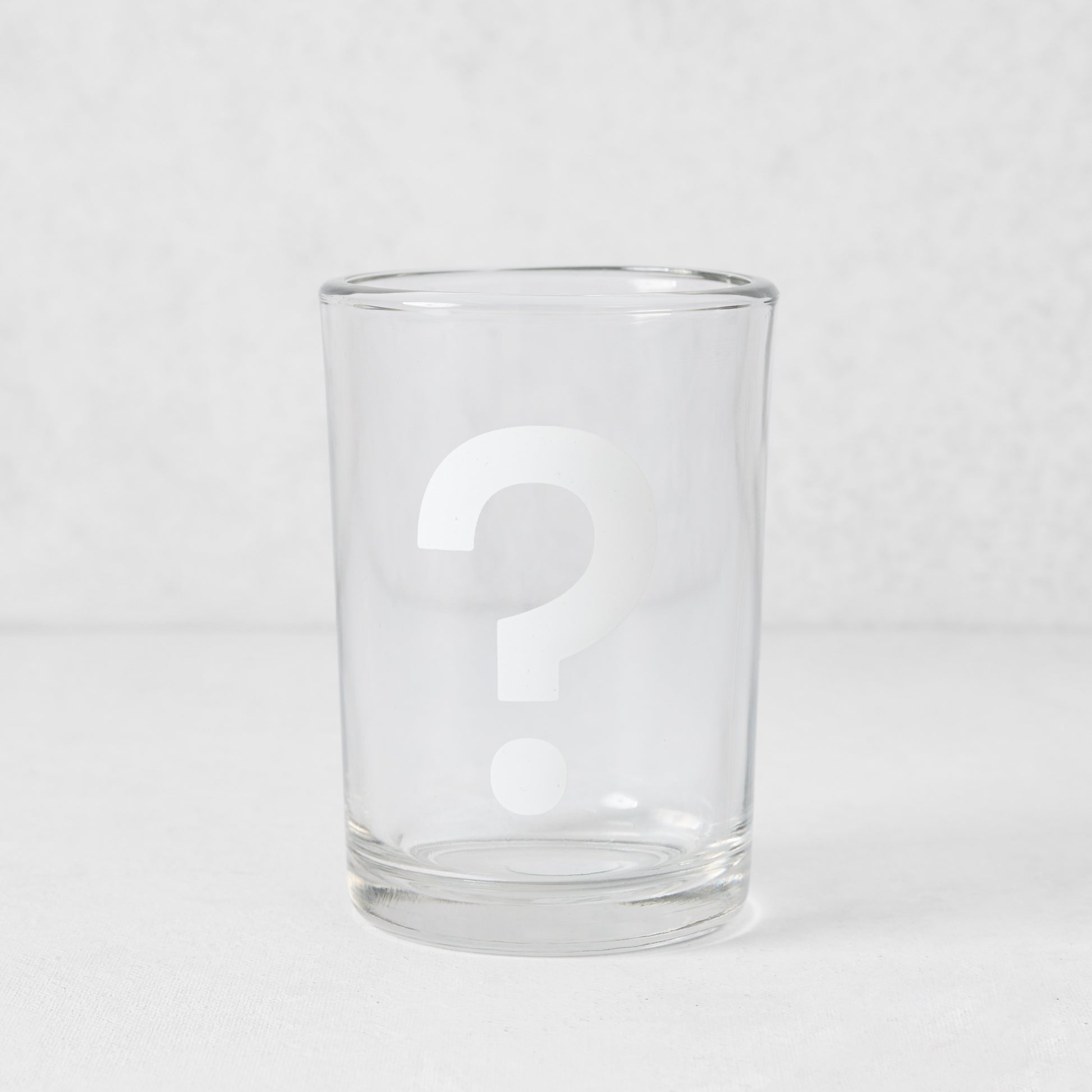 Clear glass everyday wine glass with a white question mark design.