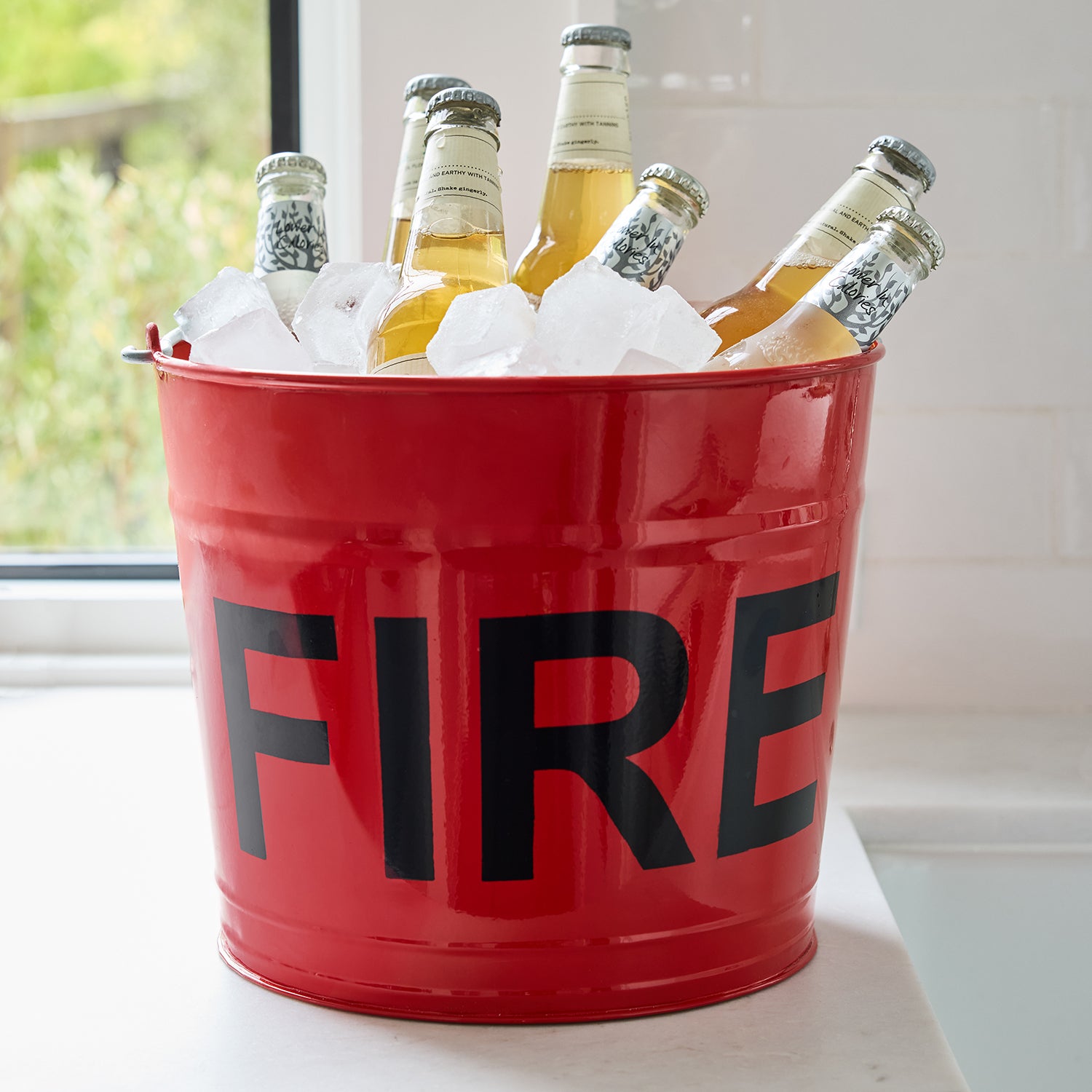 Diane Keaton x Hudson Grace red galvanized steel "FIRE" bucket with ice and bottled drinks.