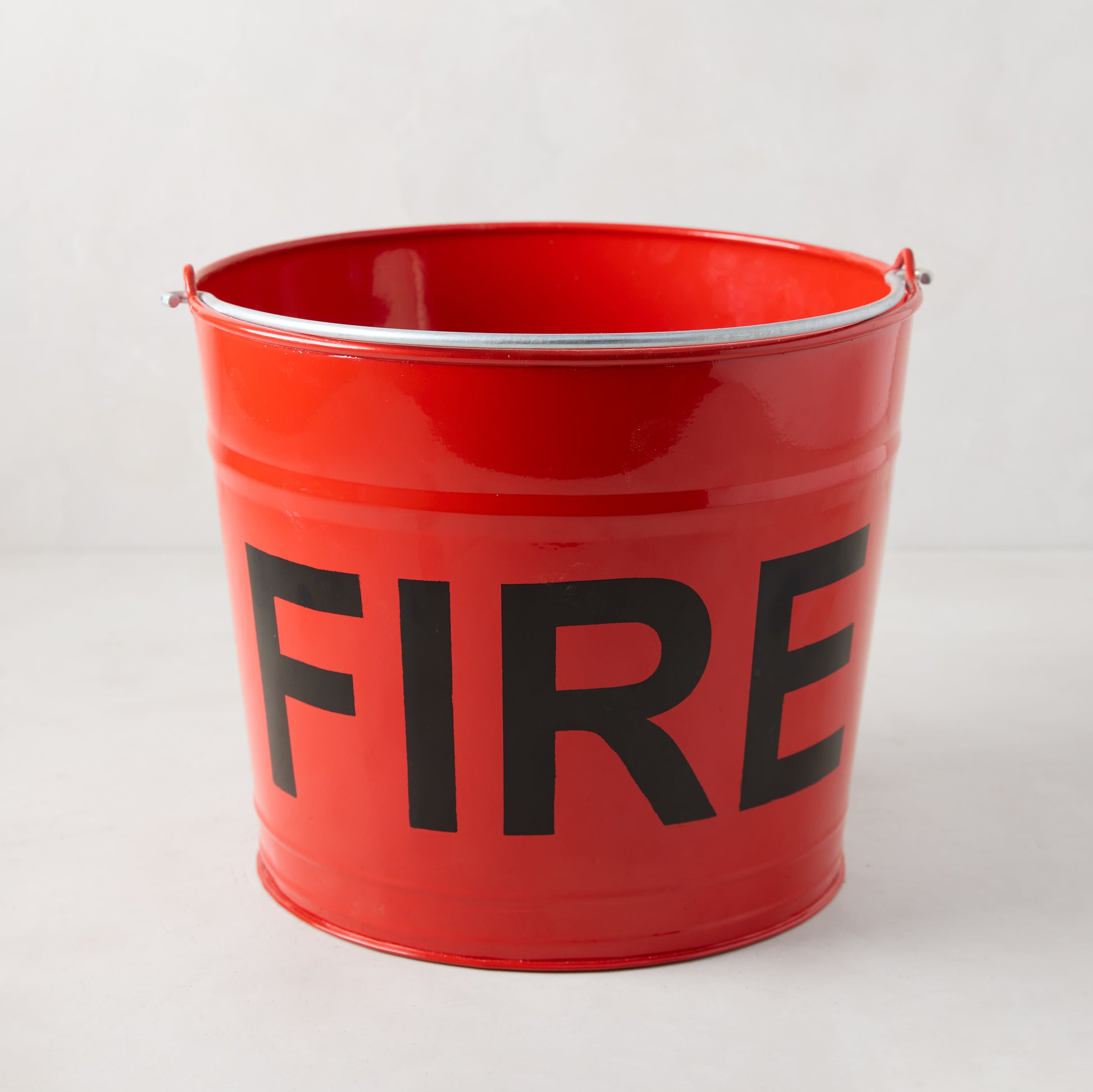 Diane Keaton x Hudson Grace Flame Red Galvanized Steel "Fire" Bucket with black "FIRE" graphic.