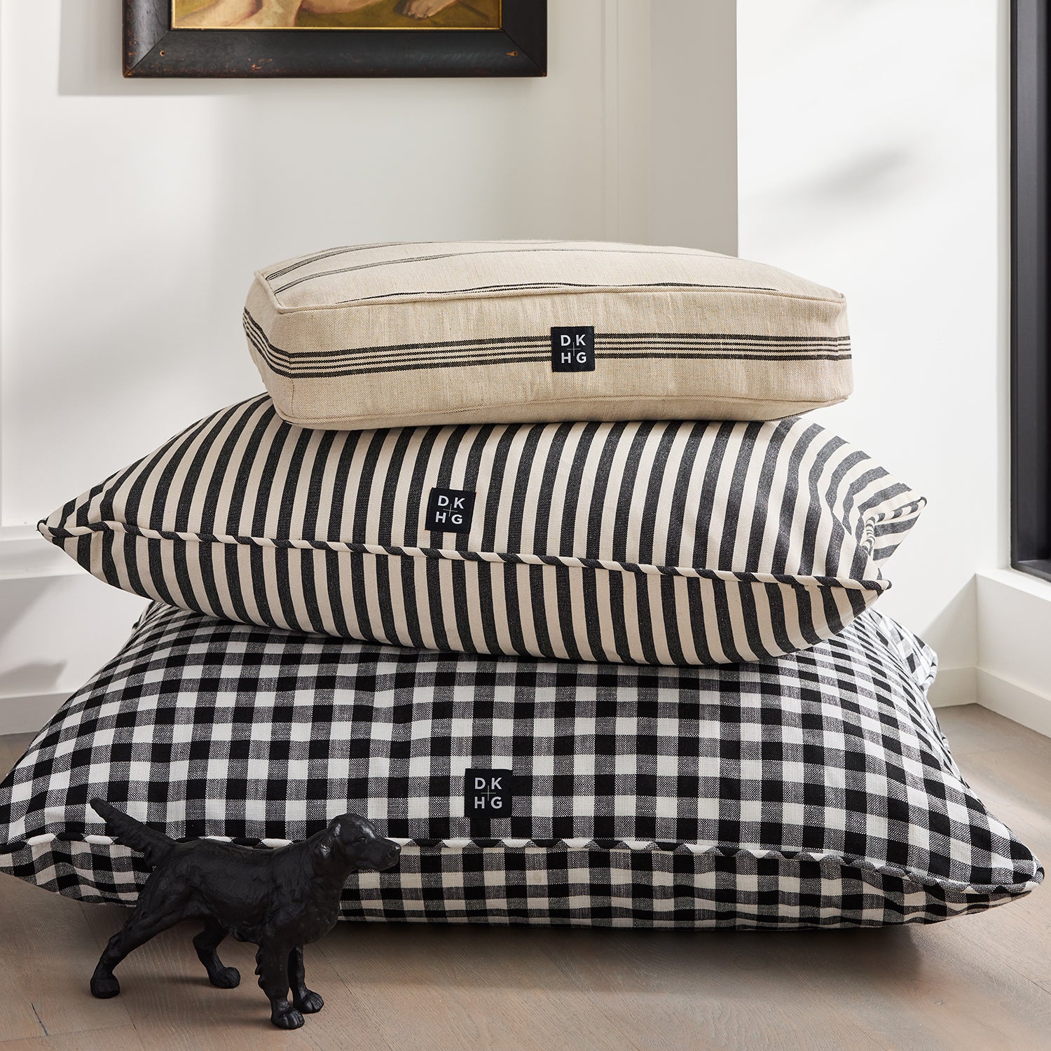 Diane Keaton x Hudson Grace dog bed stack: natural stripe, black stripe, black gingham, with "Reggie" cast iron dog.
