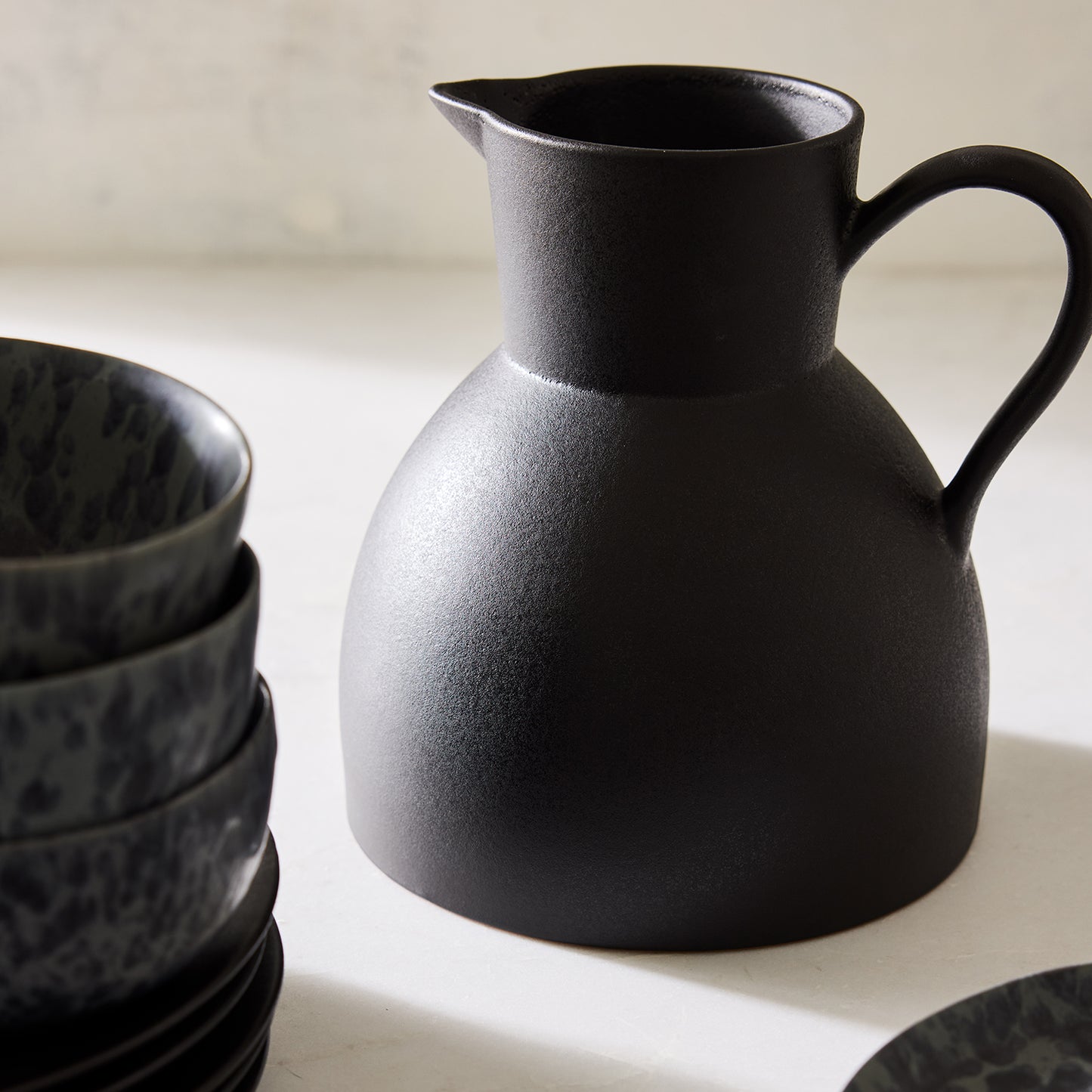 Diane Keaton + Hudson Grace sculptural black stoneware pitcher with a matte finish.