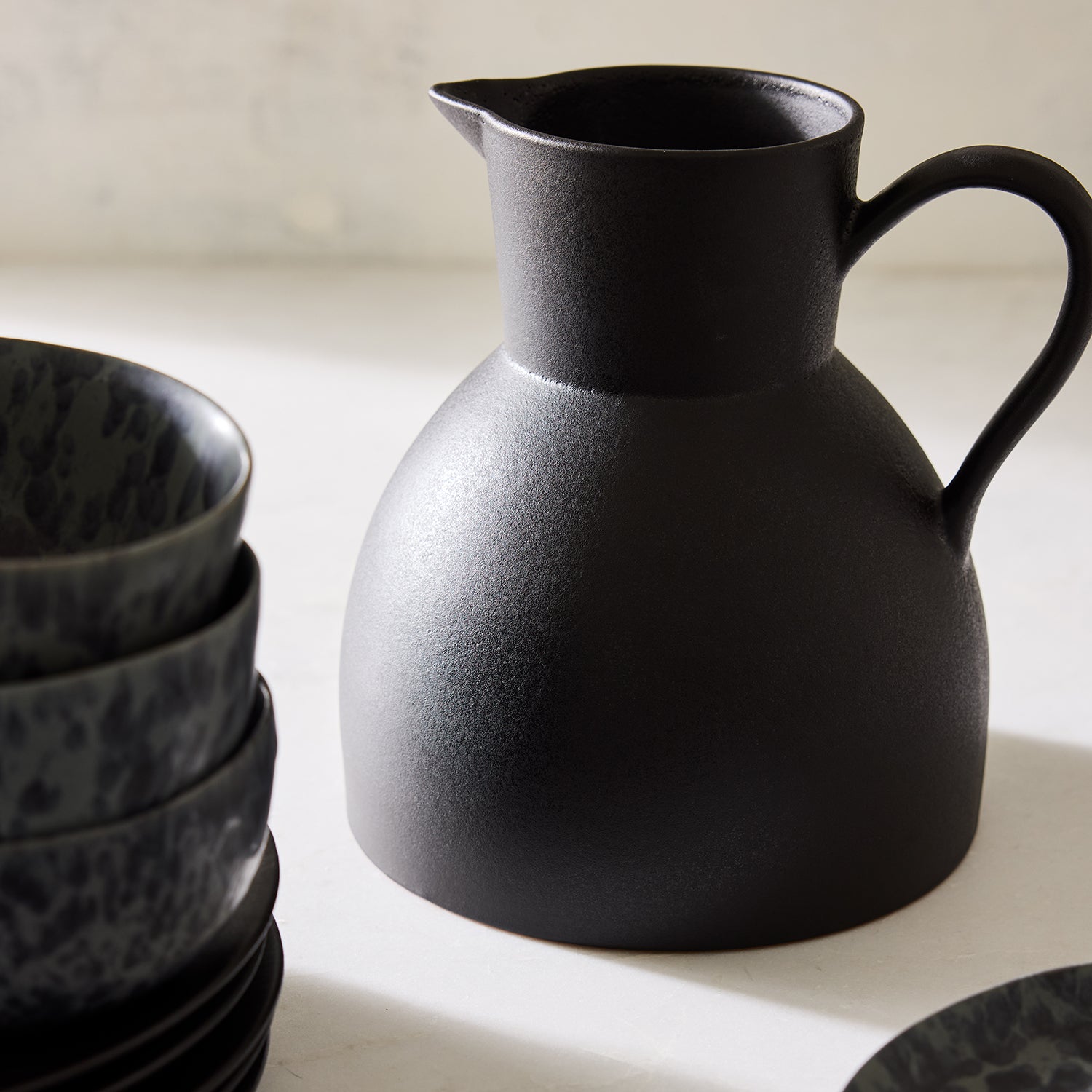 Diane Keaton + Hudson Grace sculptural black stoneware pitcher with a matte finish.