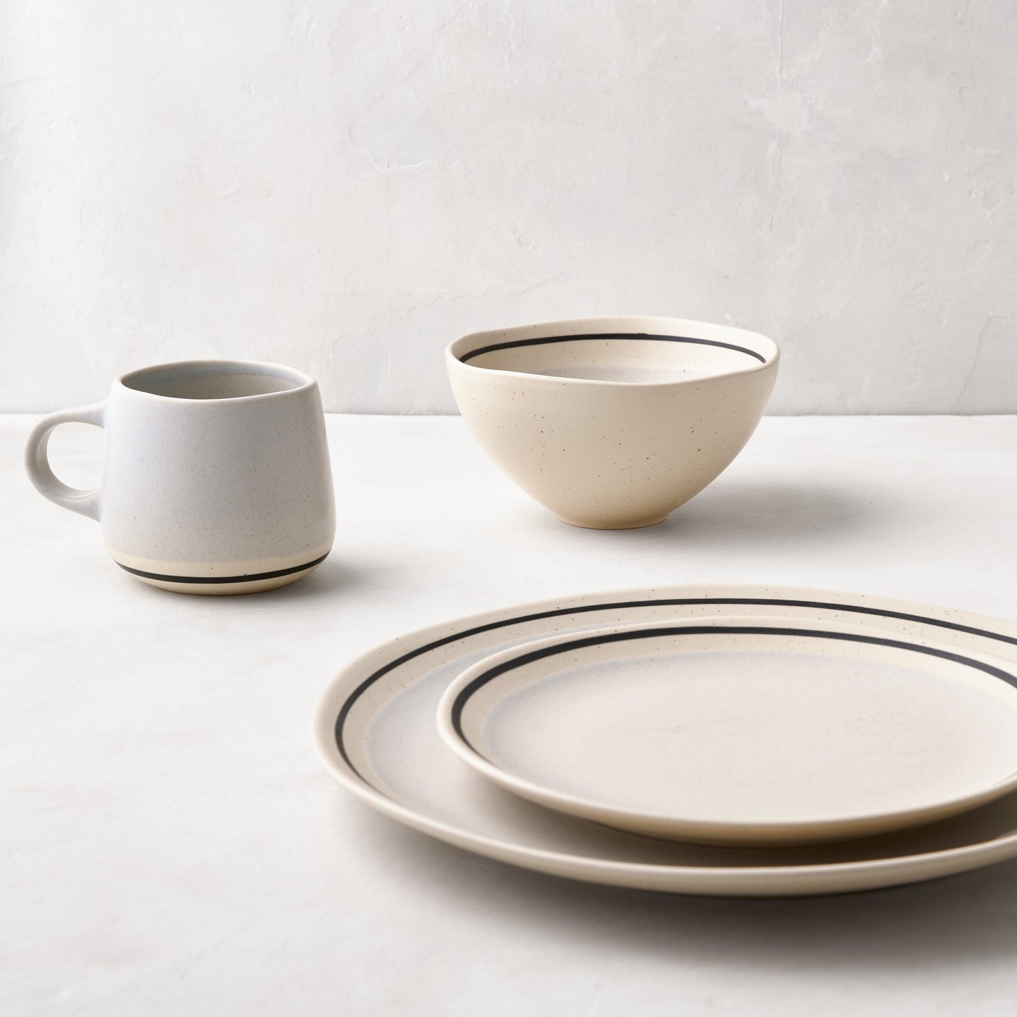 Diane Keaton + Hudson Grace speckled stoneware dinner plates, bowl, and mug with black sketch lines.