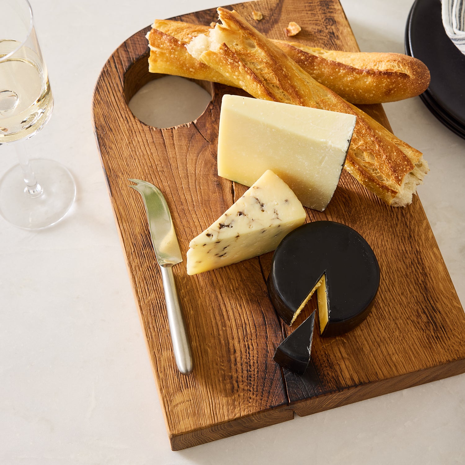 Diane Keaton + Hudson Grace Small Oak Barnwood Serving Board with circular handle, cheese, and bread.