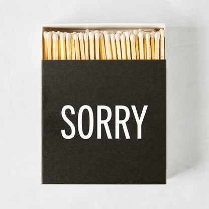 Black box of Diane Keaton + Hudson Grace "SORRY" matches with natural wood sticks.