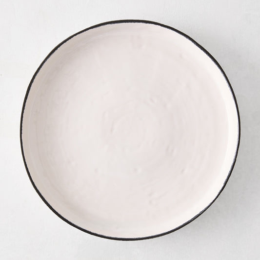 Diane Keaton + Hudson Grace Studio black rim stoneware dinner plate, irregular shape, textured white base.