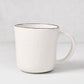 Diane Keaton + Hudson Grace Studio black rim stoneware mug with textured white base.