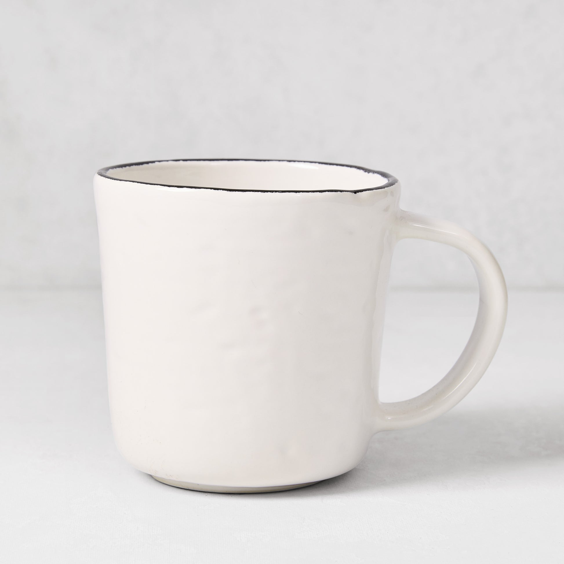 Diane Keaton + Hudson Grace Studio black rim stoneware mug with textured white base.