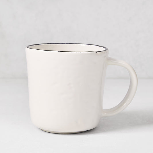 Diane Keaton + Hudson Grace Studio black rim stoneware mug with textured white base.