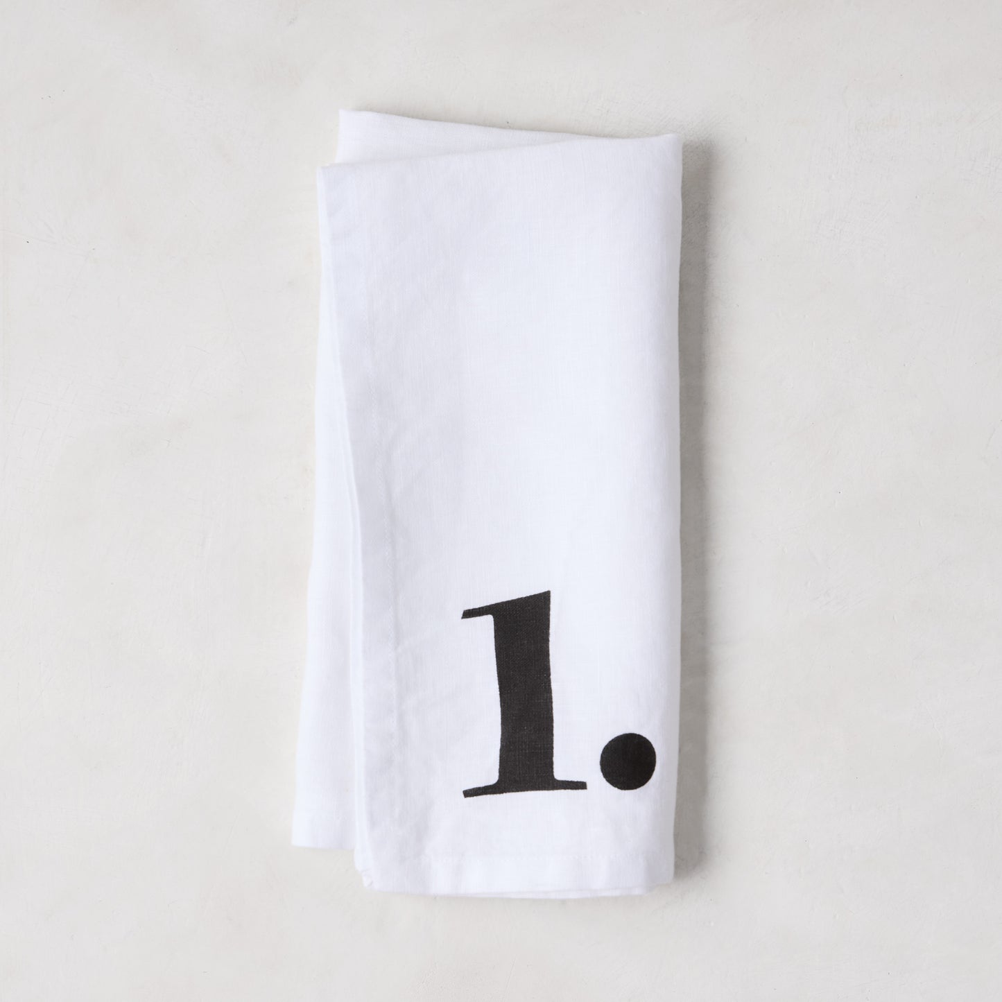 Diane Keaton + Hudson Grace white linen napkin with a bold black number 1.