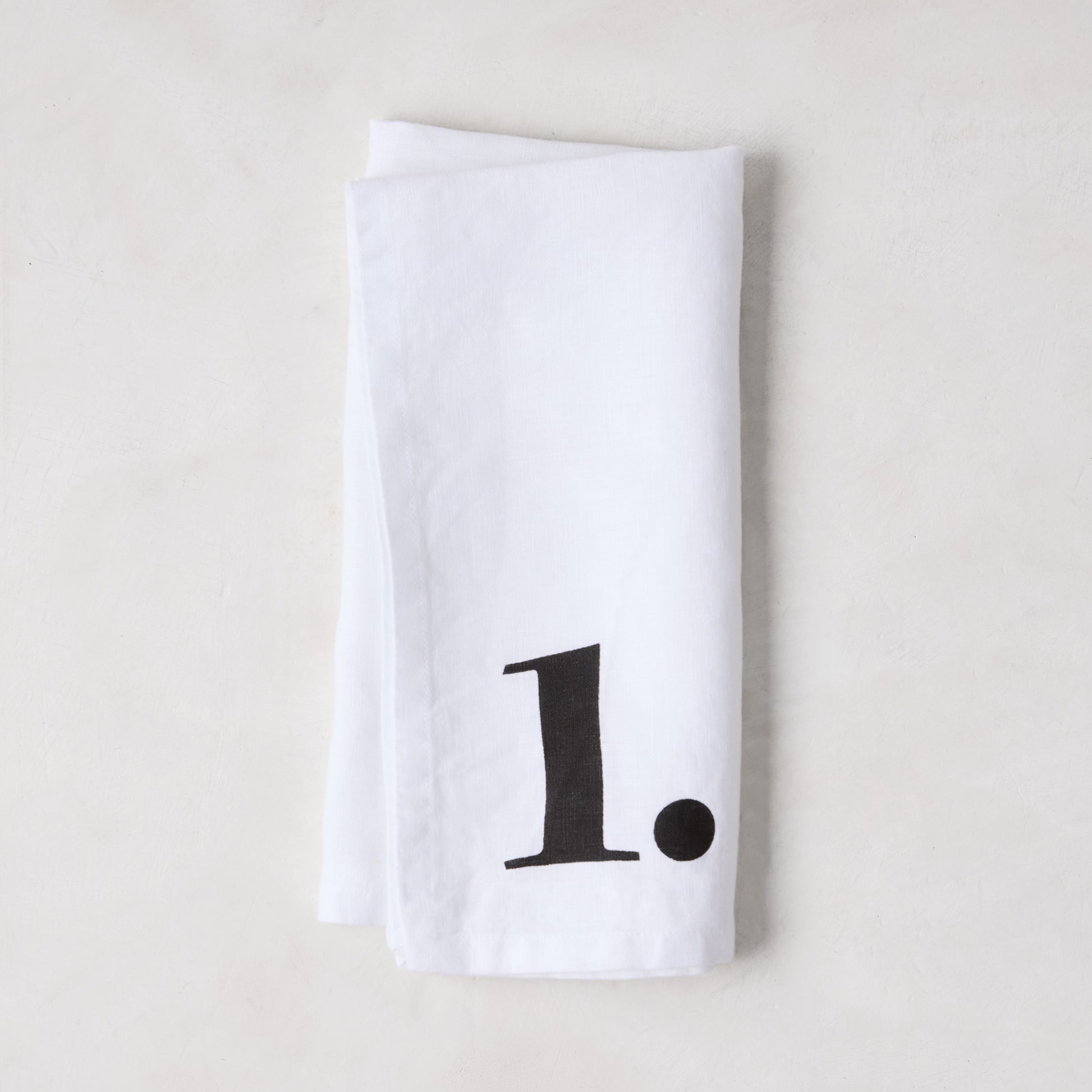 Diane Keaton + Hudson Grace white linen napkin with a bold black number 1.
