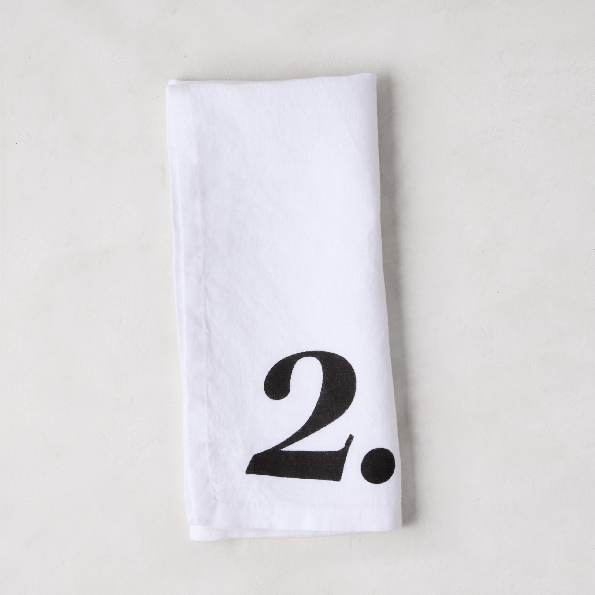 Diane Keaton + Hudson Grace white linen napkin with a bold black number 2.