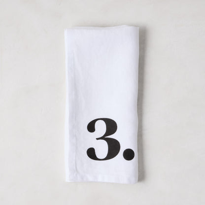 Diane Keaton + Hudson Grace white linen napkin with a bold black number 3.