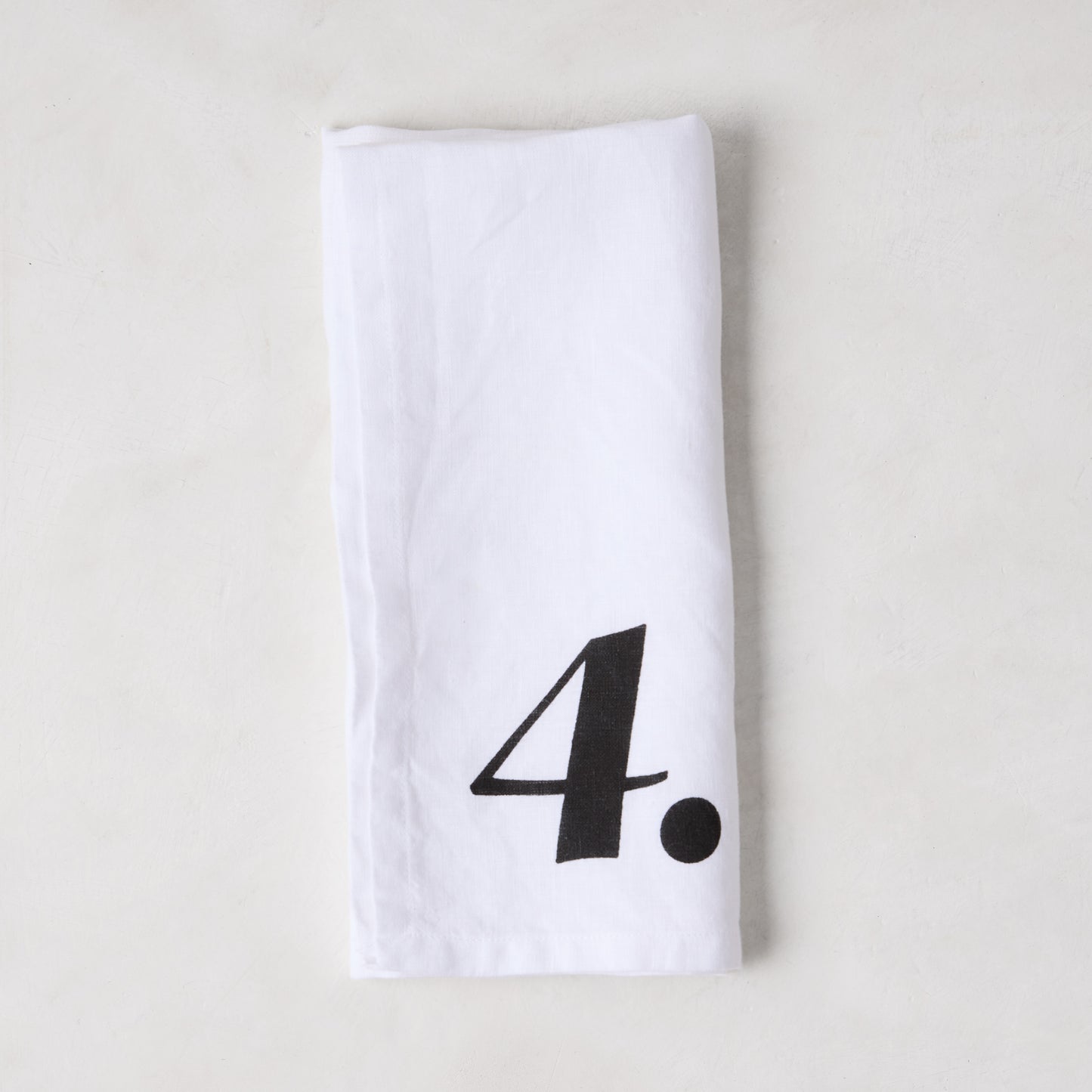 Diane Keaton + Hudson Grace white linen numeric napkin with a bold black number 4.
