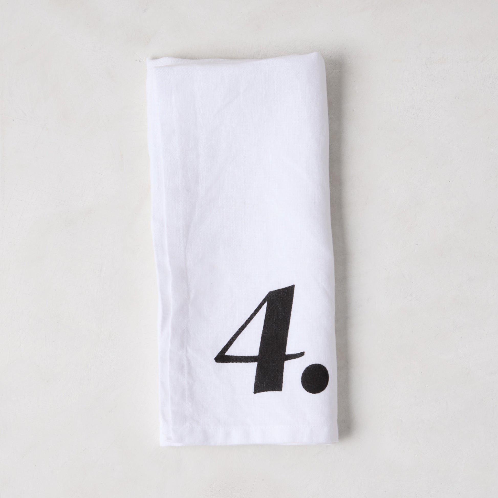 Diane Keaton + Hudson Grace white linen numeric napkin with a bold black number 4.