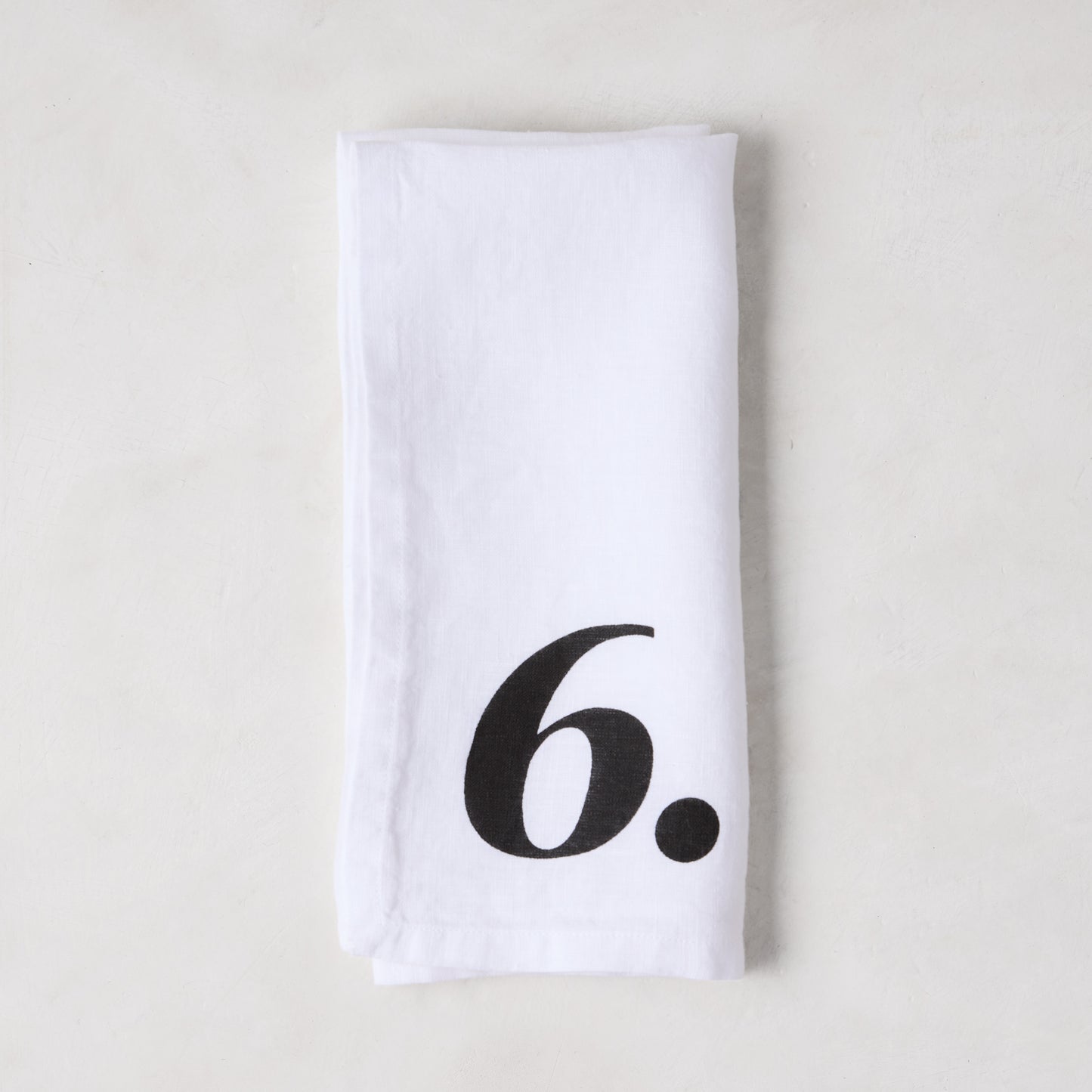 Diane Keaton + Hudson Grace white linen numeric napkin with a bold black number 6.
