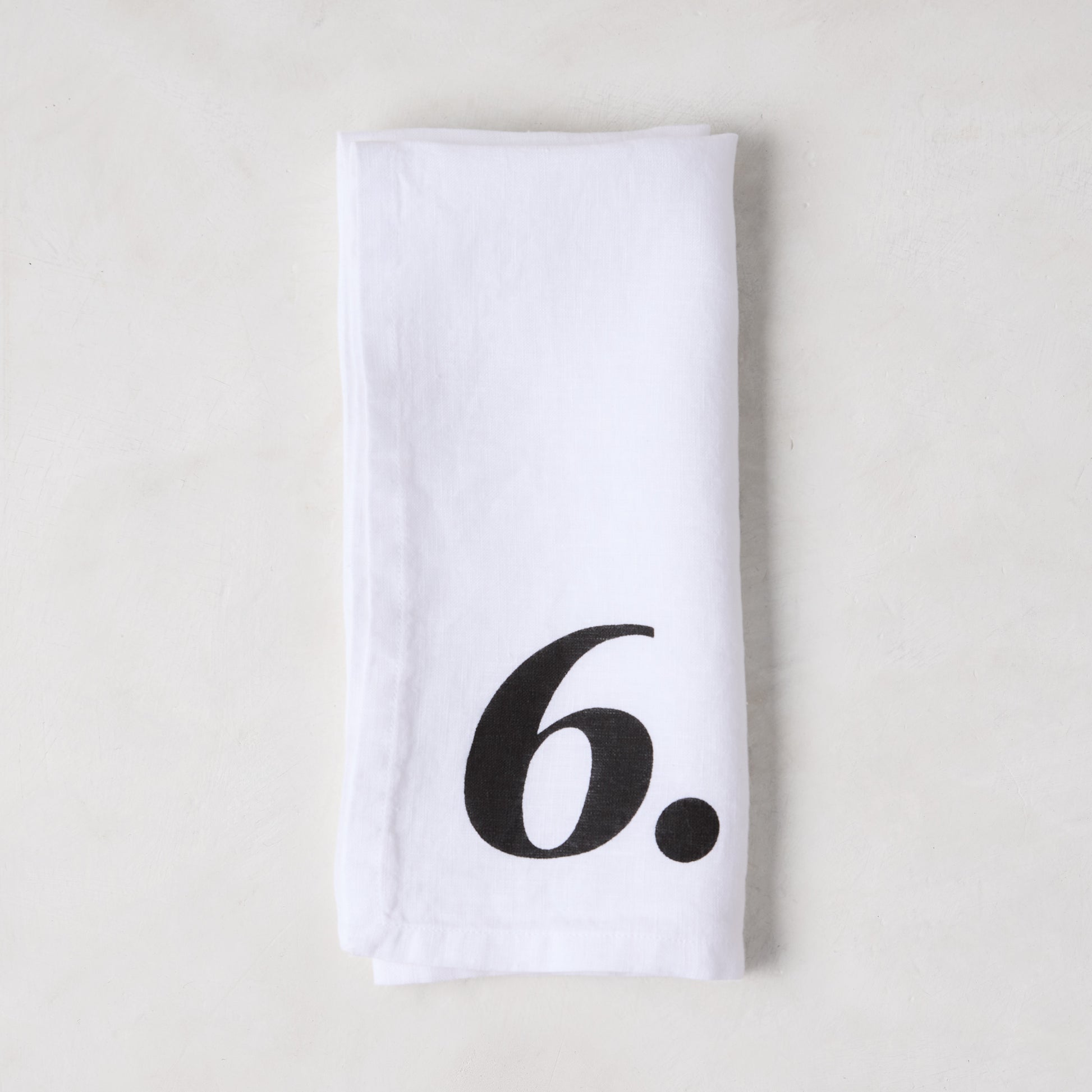 Diane Keaton + Hudson Grace white linen numeric napkin with a bold black number 6.