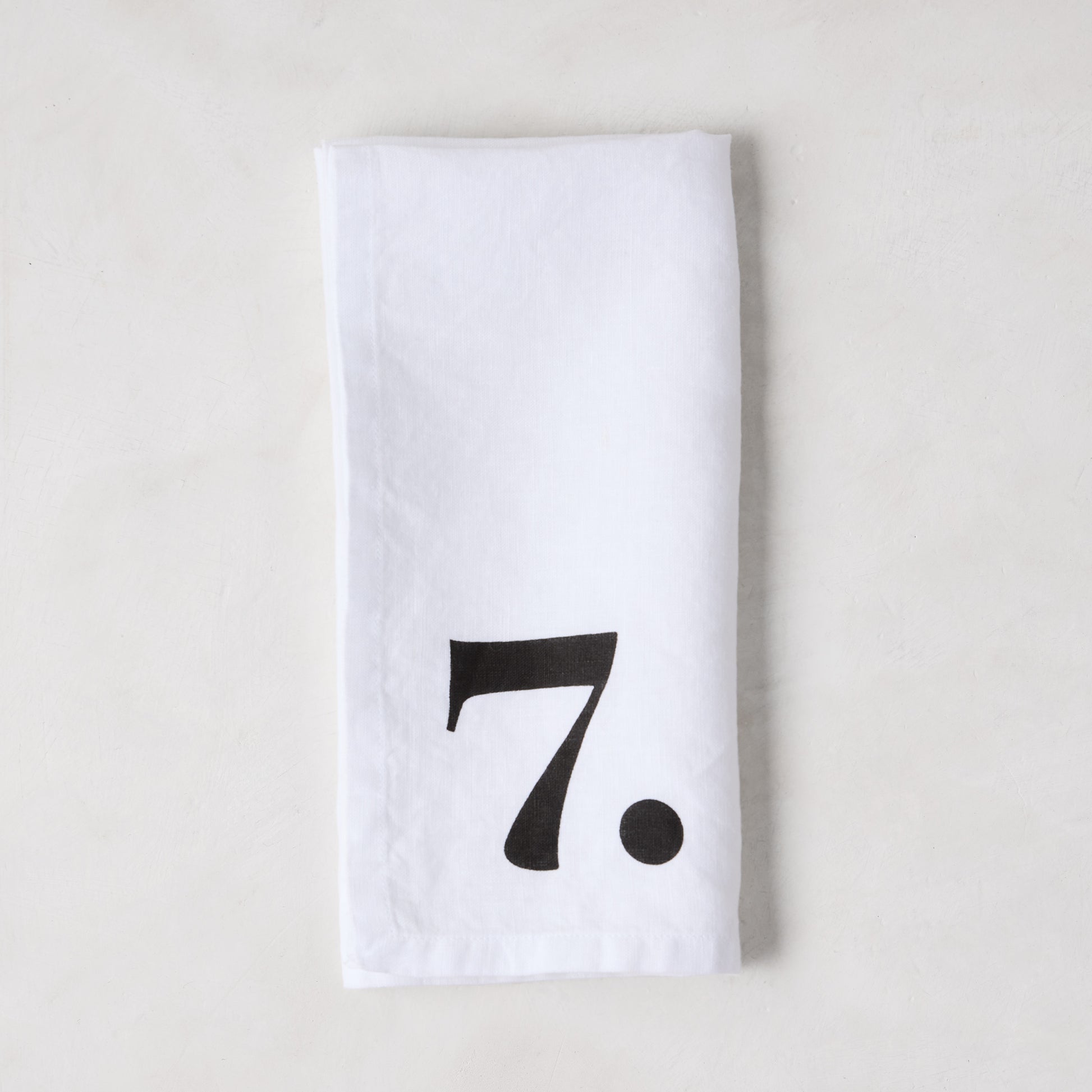 Diane Keaton + Hudson Grace white linen napkin with a bold black number 7.