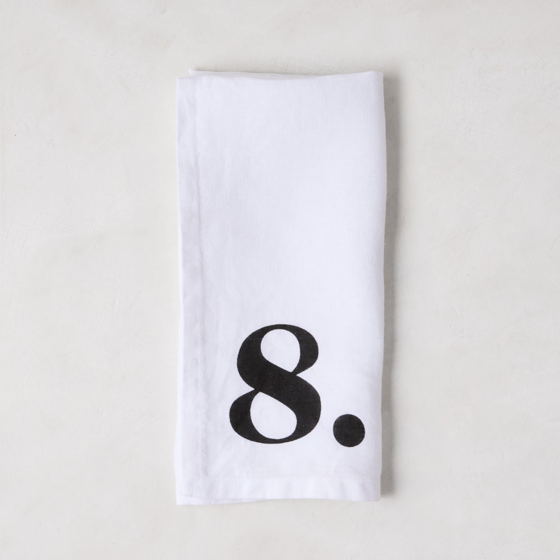 Diane Keaton + Hudson Grace white linen napkin with a bold black number 8.