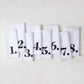Set of 8 white linen numeric napkins with bold black numbers 1-8 from the Diane Keaton + Hudson Grace collection.
