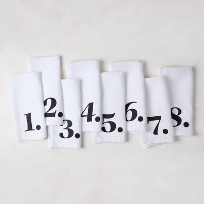 Set of 8 white linen numeric napkins with bold black numbers 1-8 from the Diane Keaton + Hudson Grace collection.