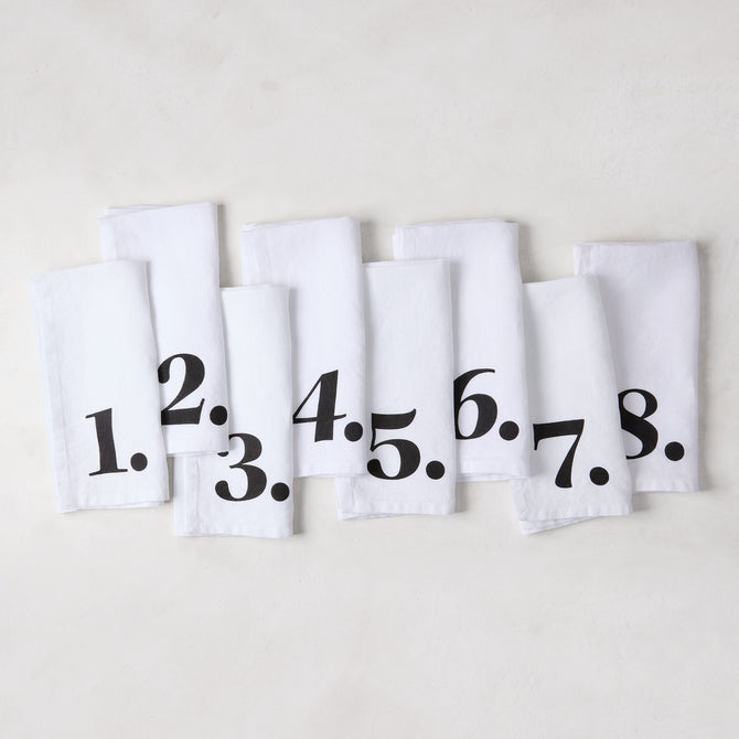 Set of 8 white linen numeric napkins with bold black numbers 1-8 from the Diane Keaton + Hudson Grace collection.