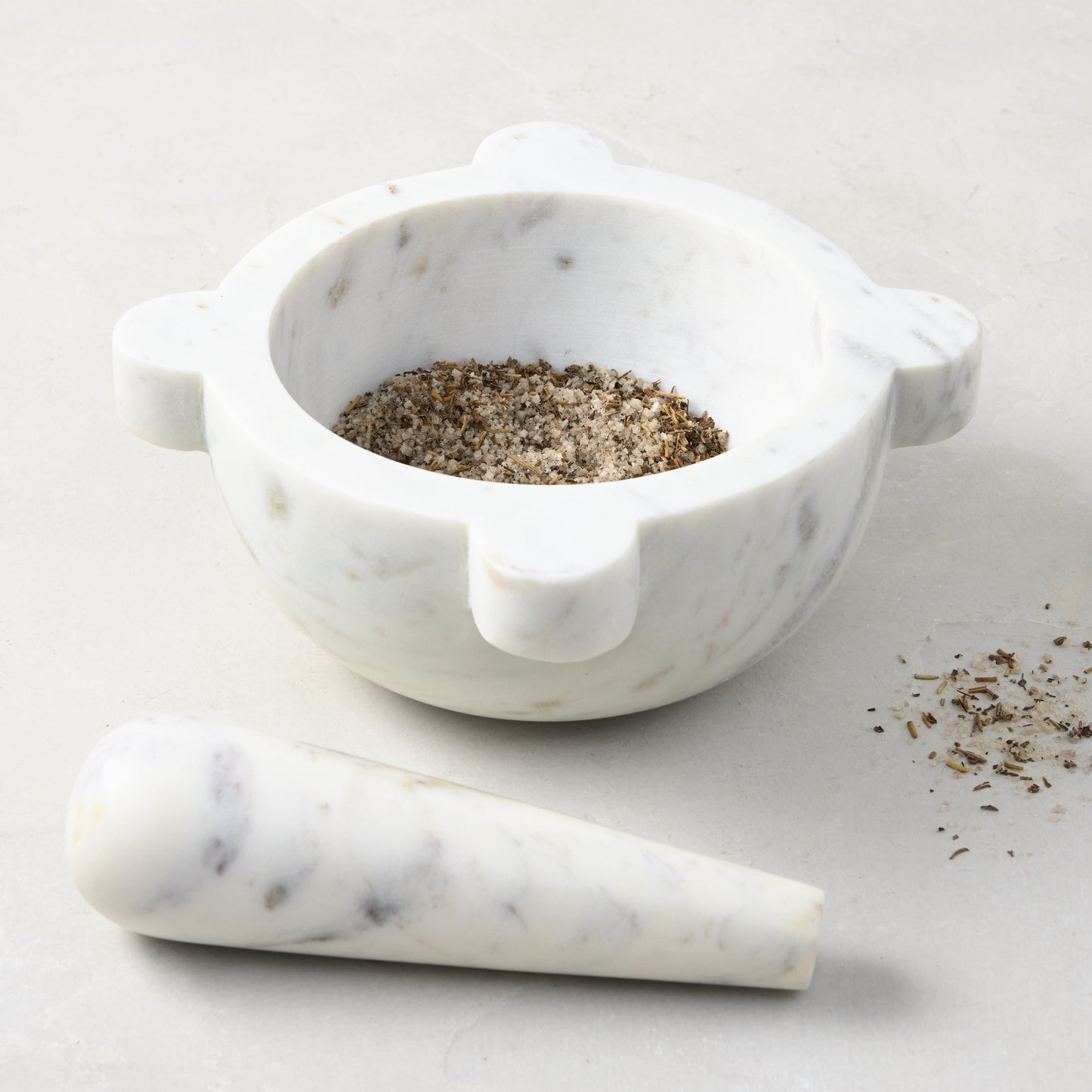 Diane Keaton + Hudson Grace white marble mortar and pestle, with spices in the mortar.