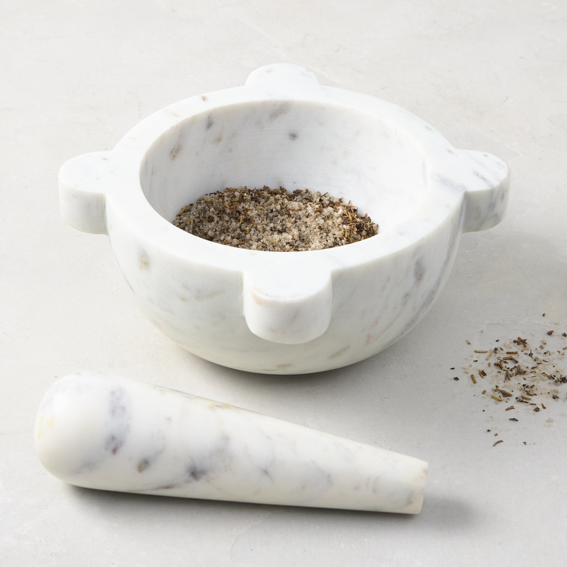 Diane Keaton + Hudson Grace white marble mortar and pestle, with spices in the mortar.