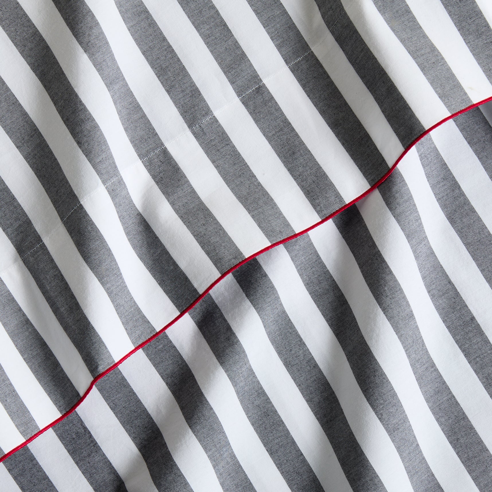 Diane Keaton + Hudson Grace gray and white striped percale sheet set with red trim.