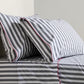 Diane Keaton + Hudson Grace gray and white striped percale sheet set with red trim.